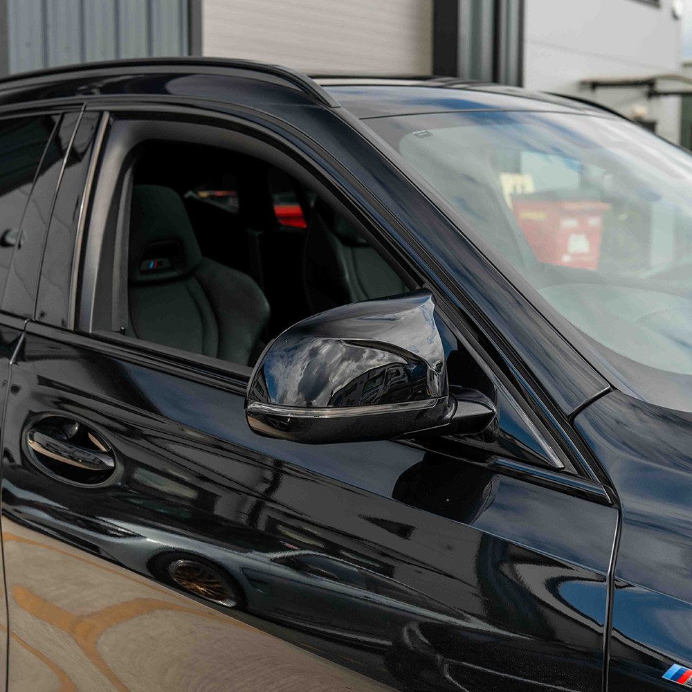Gloss black BMW X3/X4/X5/X6 G01/G02/G05/G06 mirror covers by CT Carbon, featuring aerodynamic design and high-quality finish.
