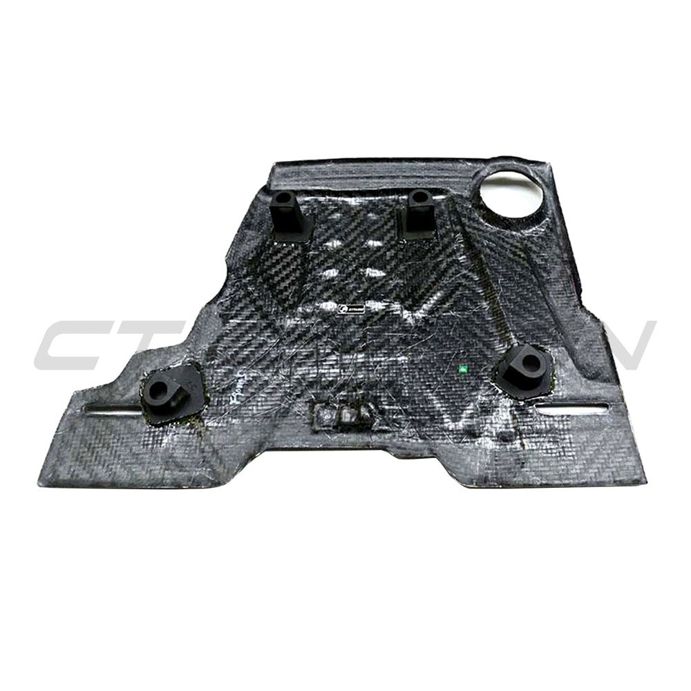 Carbon fiber engine cover for BMW F90 M5 and M8 models, by CT Carbon, showcasing sleek, textured finish on engine bay.