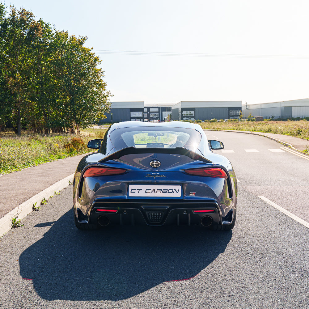 Toyota Supra 2019+ A90 carbon fiber diffuser add-on by CT Carbon, showing sleek aerodynamic design on the car's rear.