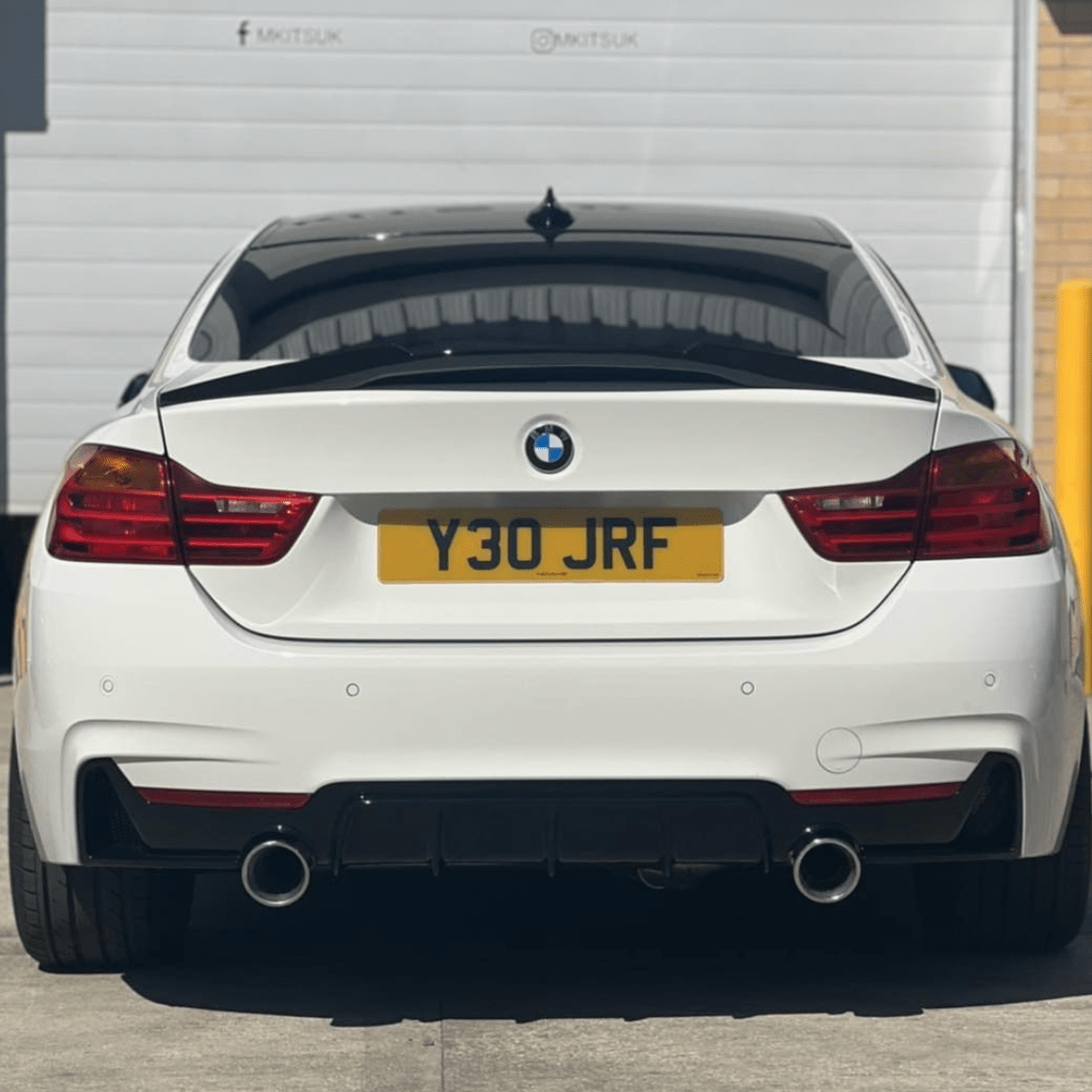 BMW 4 Series F32 gloss black M-style spoiler by CT Carbon, showcasing sleek aerodynamic design for the vehicle's rear.
