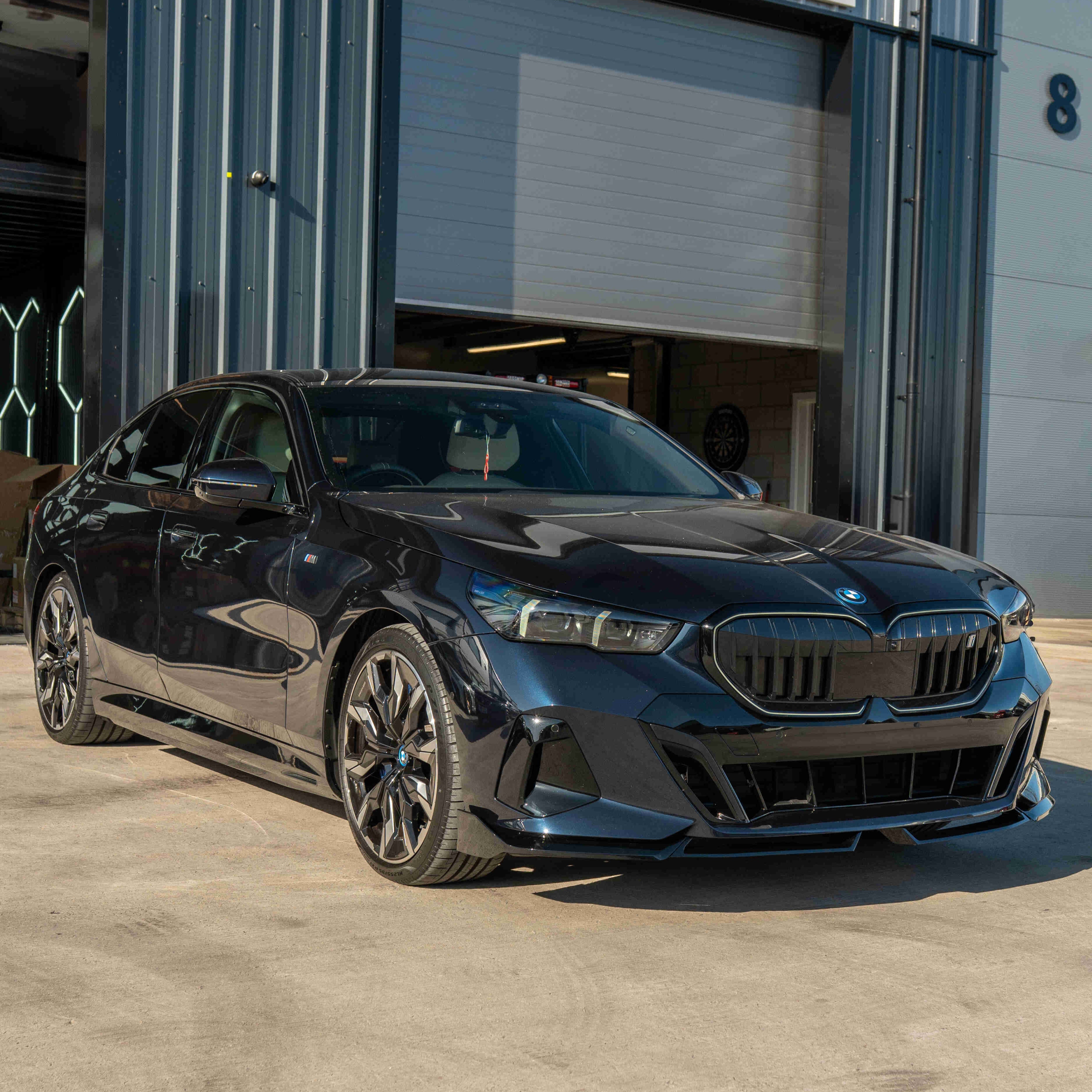 BMW 5 Series G60 and i5 2023 CT Carbon gloss black splitter installed on front bumper, enhancing sporty appearance.