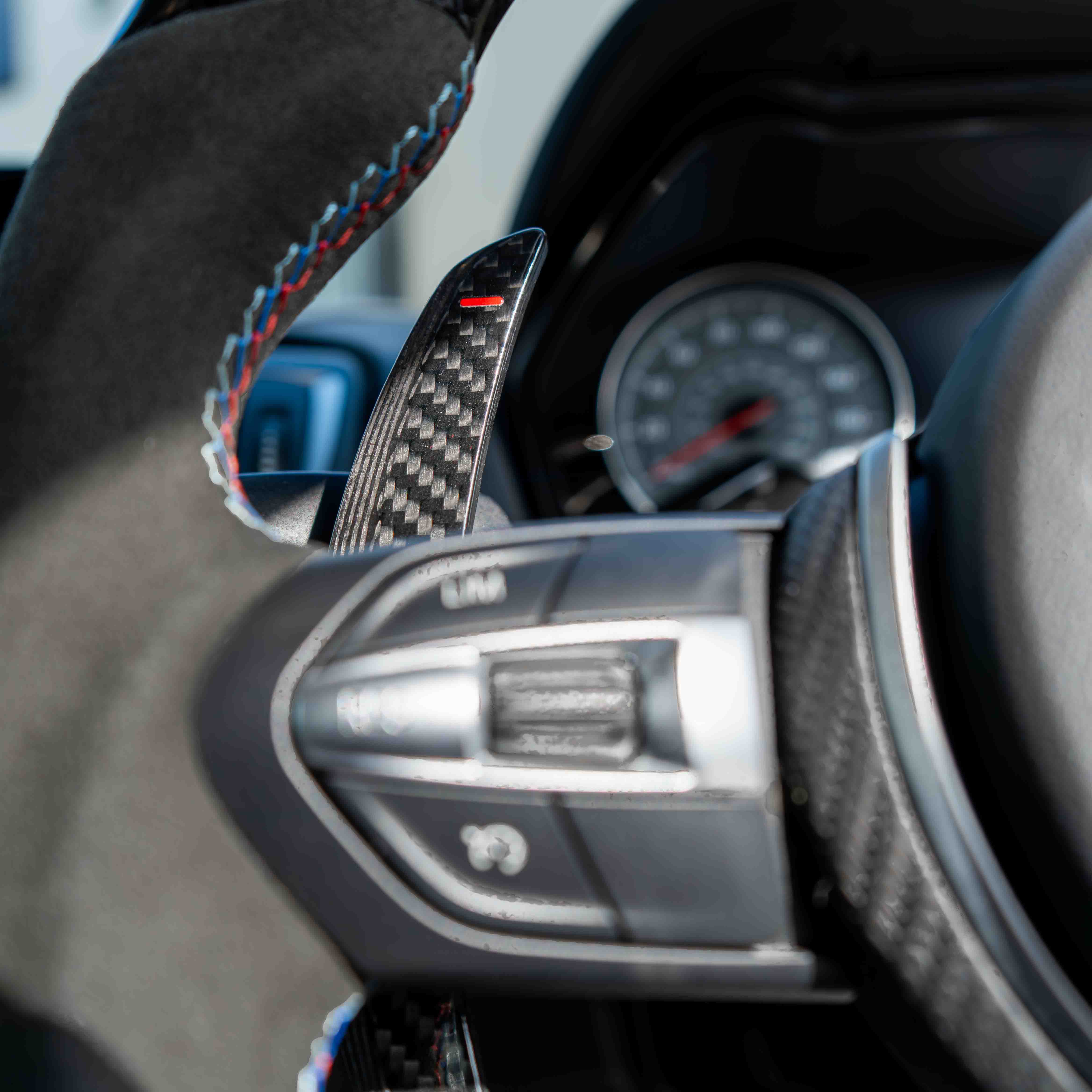BMW carbon fiber magnetic shifter paddles by CT Carbon, sleek and lightweight car accessory with textured carbon fiber finish.