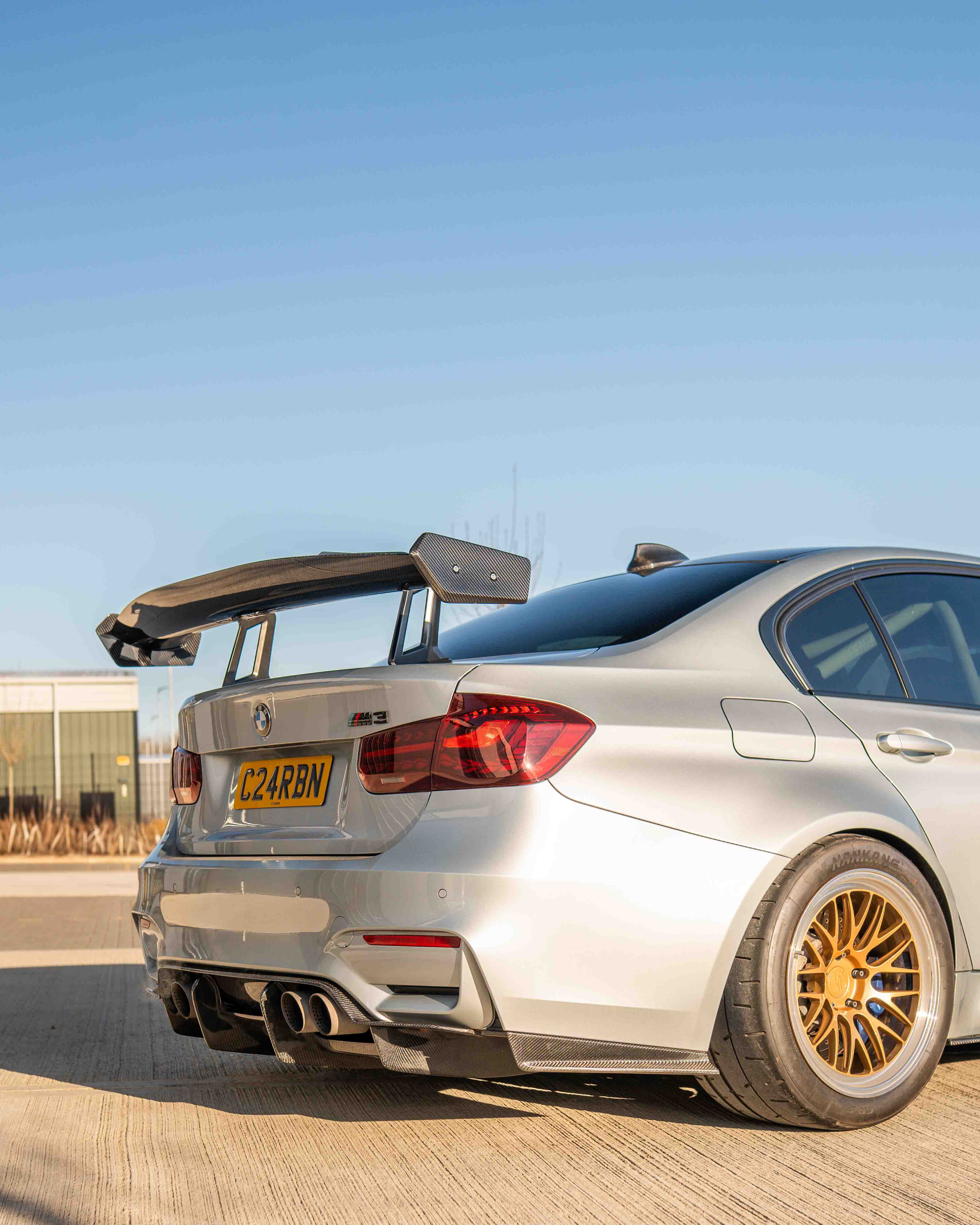 BMW F80 M3 and F30 3 Series carbon fiber swan neck wing spoiler by CT Carbon, showcasing sleek aerodynamic design.
