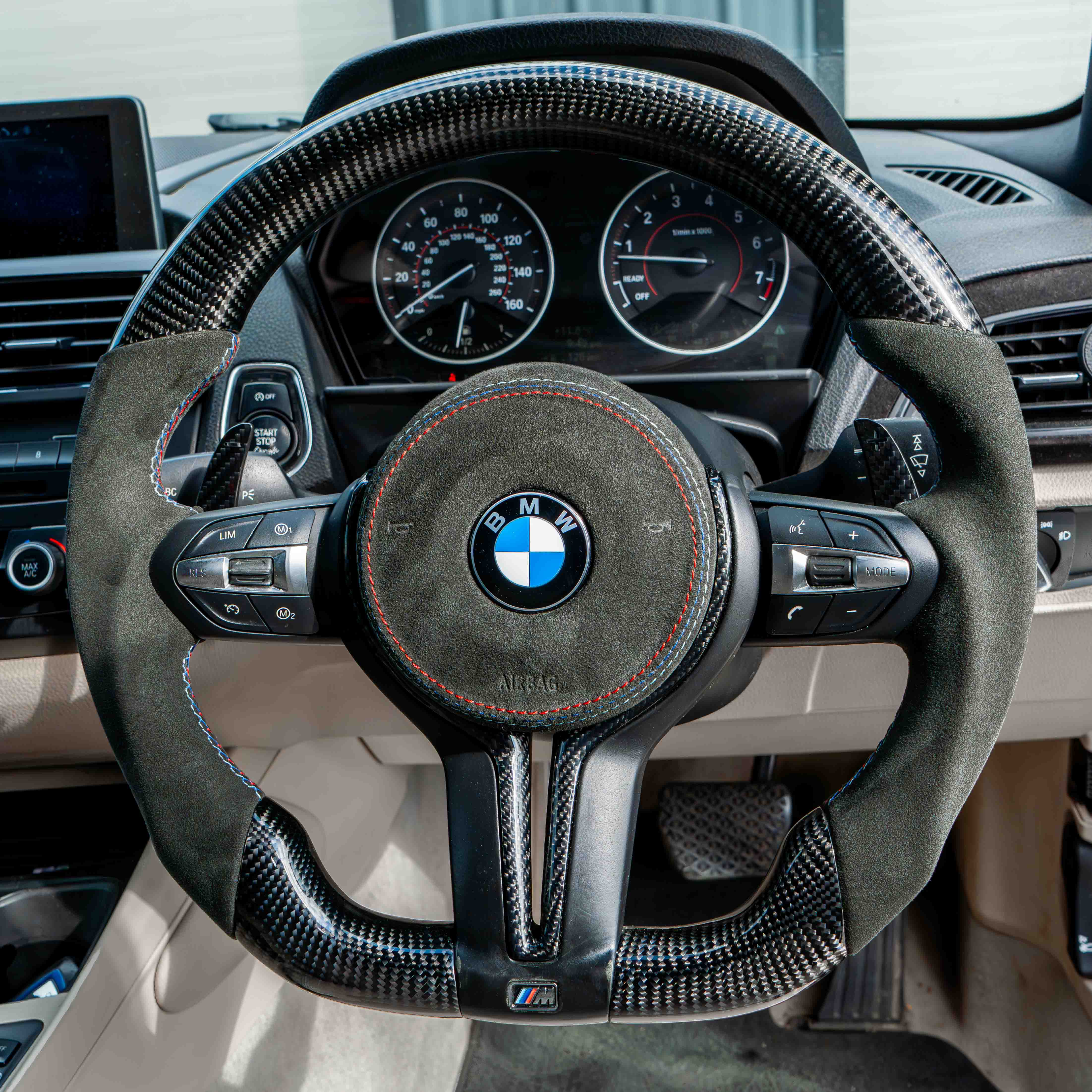 BMW Fxx carbon fiber magnetic shifter paddles, CT Carbon accessories, close-up view showing sleek black finish and paddle design.