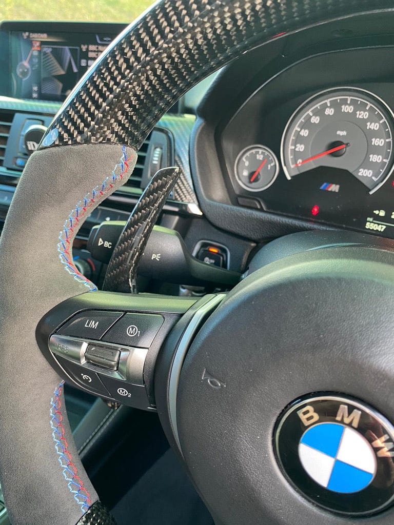 BMW Fxx carbon fibre shifter paddles by CT Carbon, showing sleek, lightweight racing-style gear shift paddles on a car steering wheel.