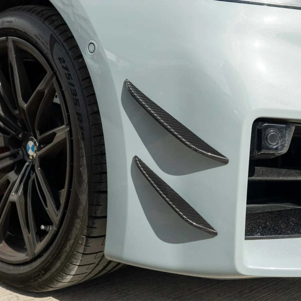 BMW G87 M2 carbon fibre front bumper canards by CT Carbon, lightweight aerodynamic accessories with a sleek carbon finish.