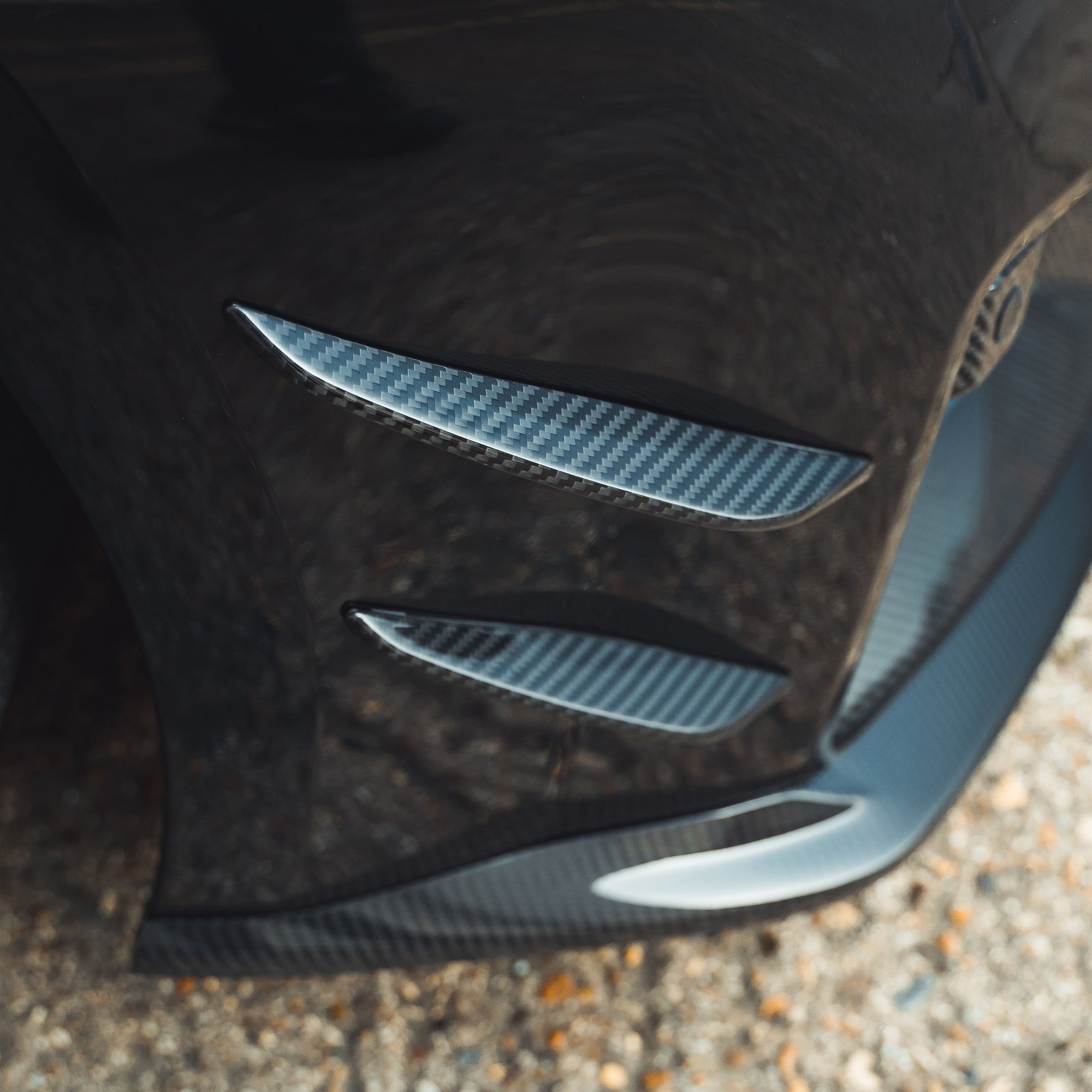 BMW G87 M2 carbon fiber front bumper canards by CT Carbon, lightweight aerodynamic car accessories, mounted on the front bumper.