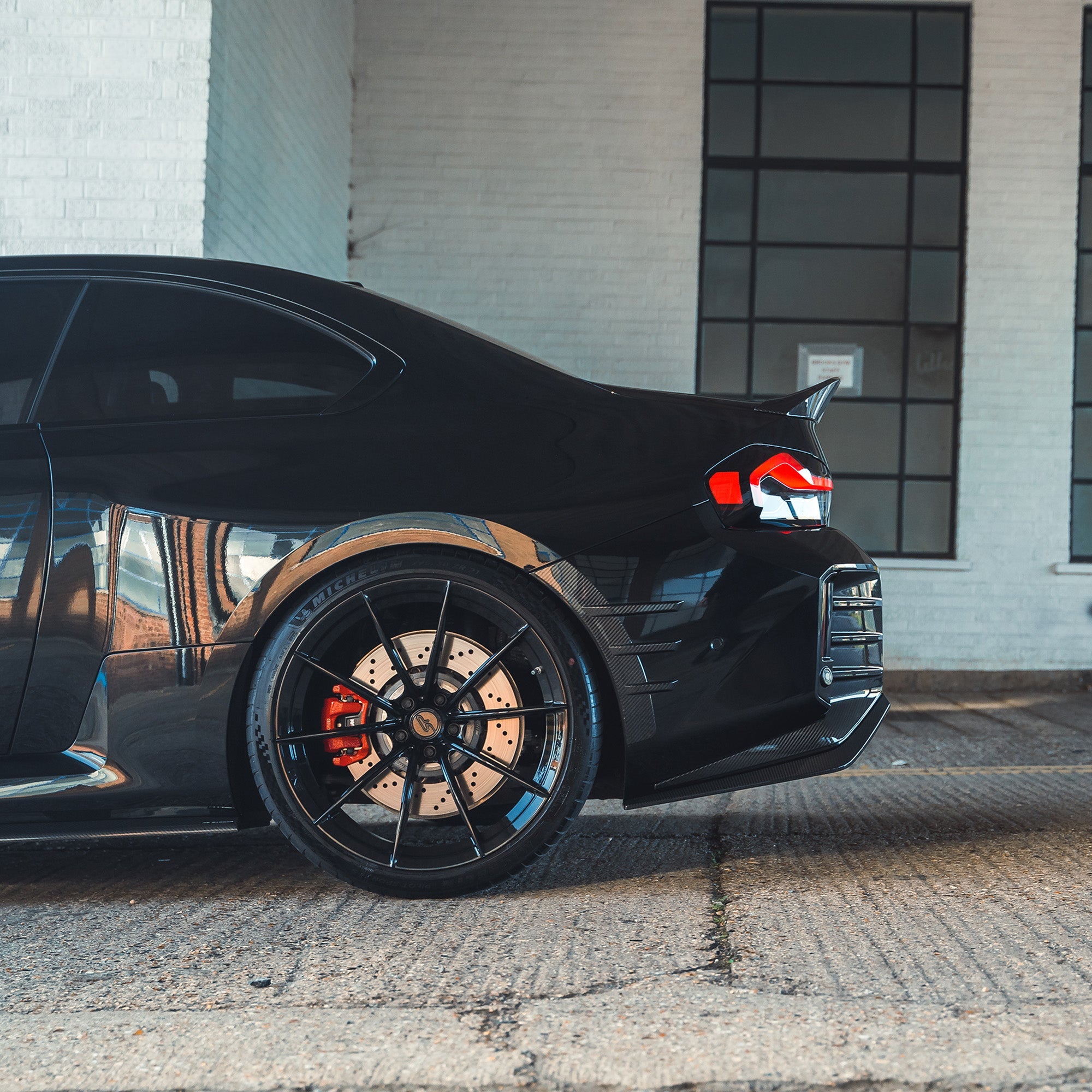 BMW G87 M2 carbon fibre rear side fender trim accessory by CT Carbon, showcasing sleek, lightweight carbon fibre design on the vehicle.