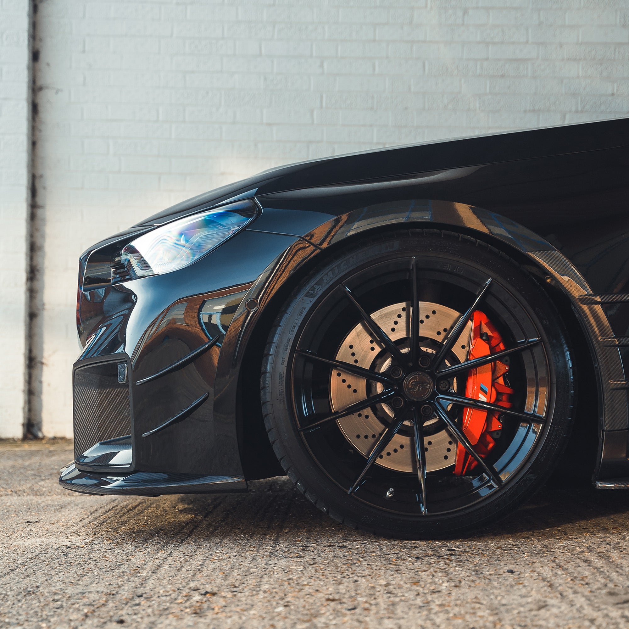 BMW G87 M2 Carbon Fibre Splitter V1 by CT Design mounted on the front bumper, showcasing lightweight carbon fiber construction.