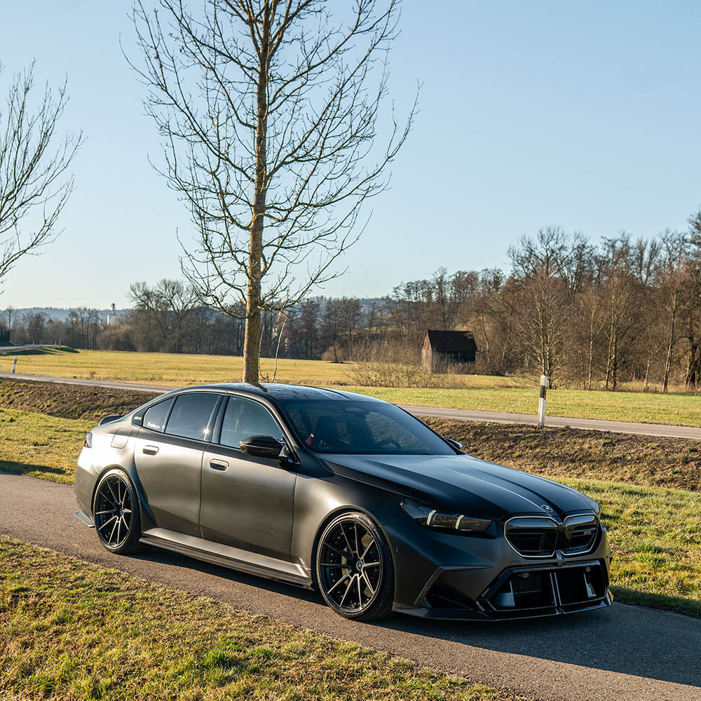 BMW G90 M5 carbon fibre full kit by CT Design, including front splitter, side skirts, and rear diffuser, displayed on a sports car.