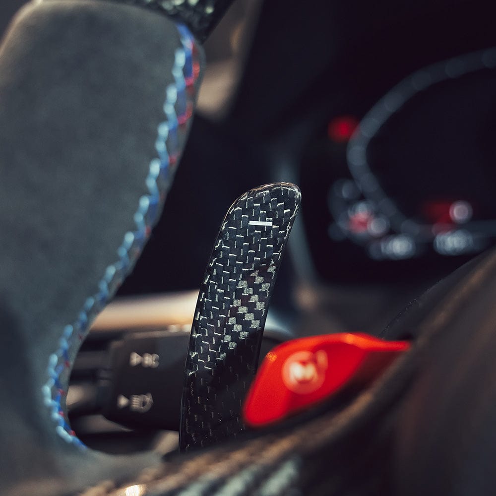 Carbon fiber BMW GXX/F40 shifter paddles by CT Carbon, showcasing sleek, lightweight racing-style accents for the car's interior.