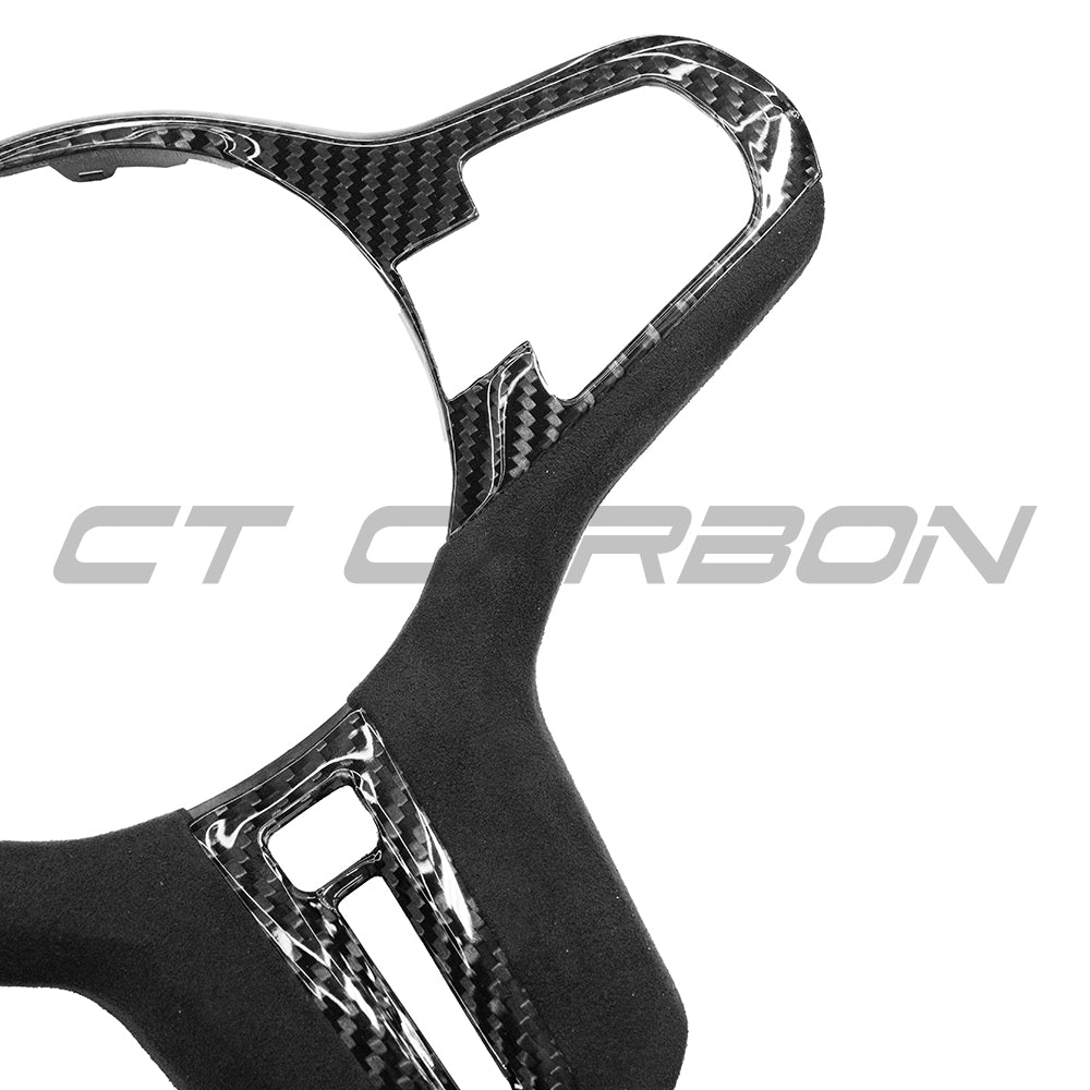 BMW Gxx M carbon fiber steering wheel trim with heating for pre-LCI models, by CT Carbon, showing close-up of textured finish.
