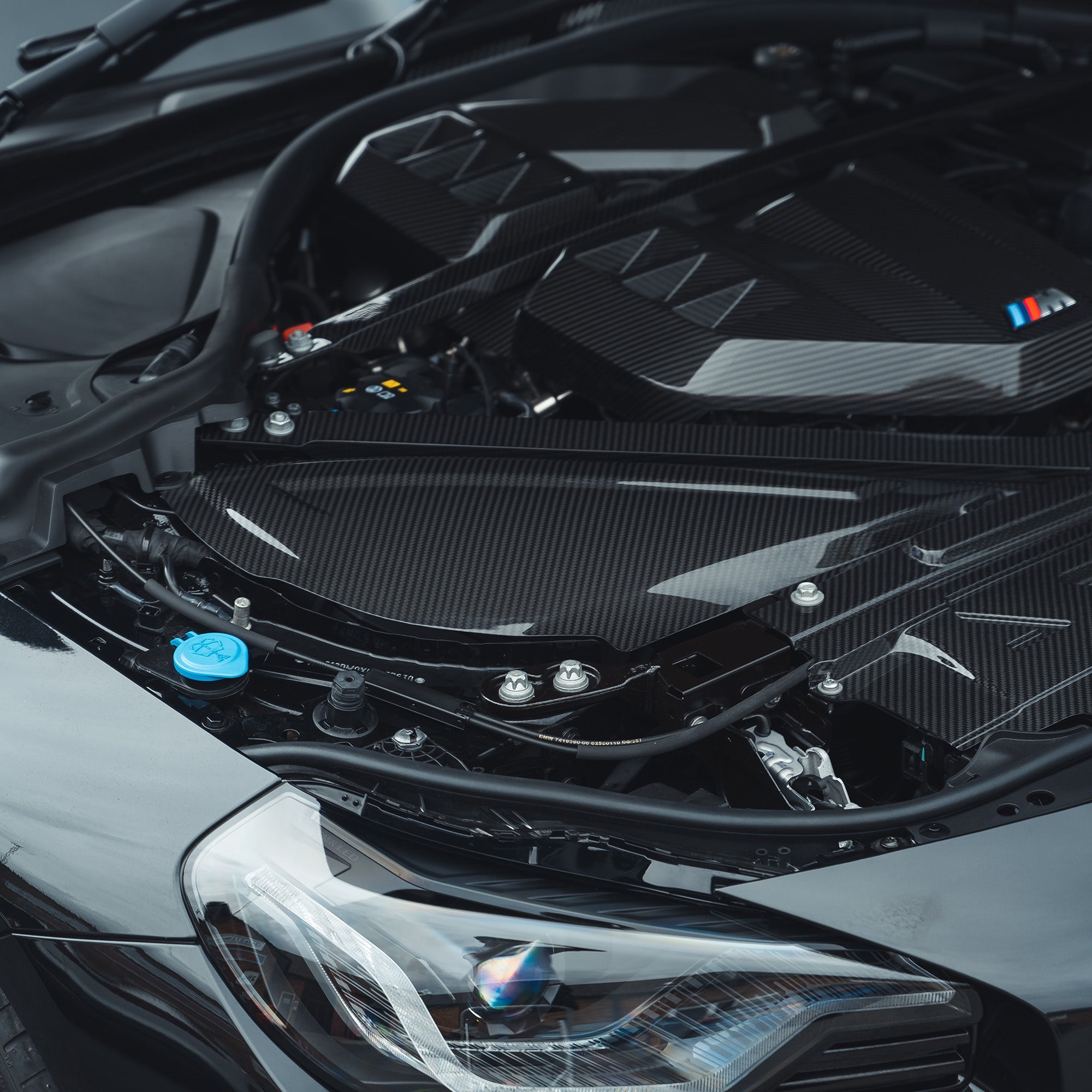 Carbon fiber air intake cover for BMW M2, M3, M4 G87, G80, G81, G82, G83 by CT Carbon, shown on engine bay.