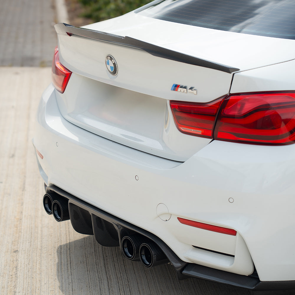Set of four black carbon fiber exhaust tips for BMW M2 M3 M4 M5 F10 F80 F82 F83 F87 by CT Carbon, showcasing sleek finish and fit.
