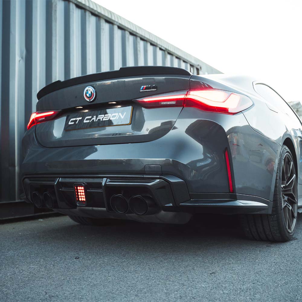 BMW M3 M4 G80 G81 G82 G83 carbon fibre diffuser with integrated LED lights, designed for sporty aerodynamic enhancement.
