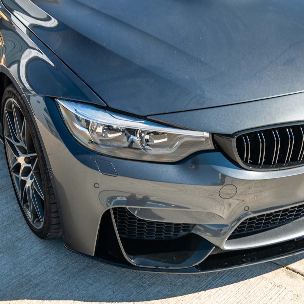 BMW M4 F82 coupe in full gloss black kit by CT Carbon, featuring sleek aerodynamic body parts and carbon fiber accents.