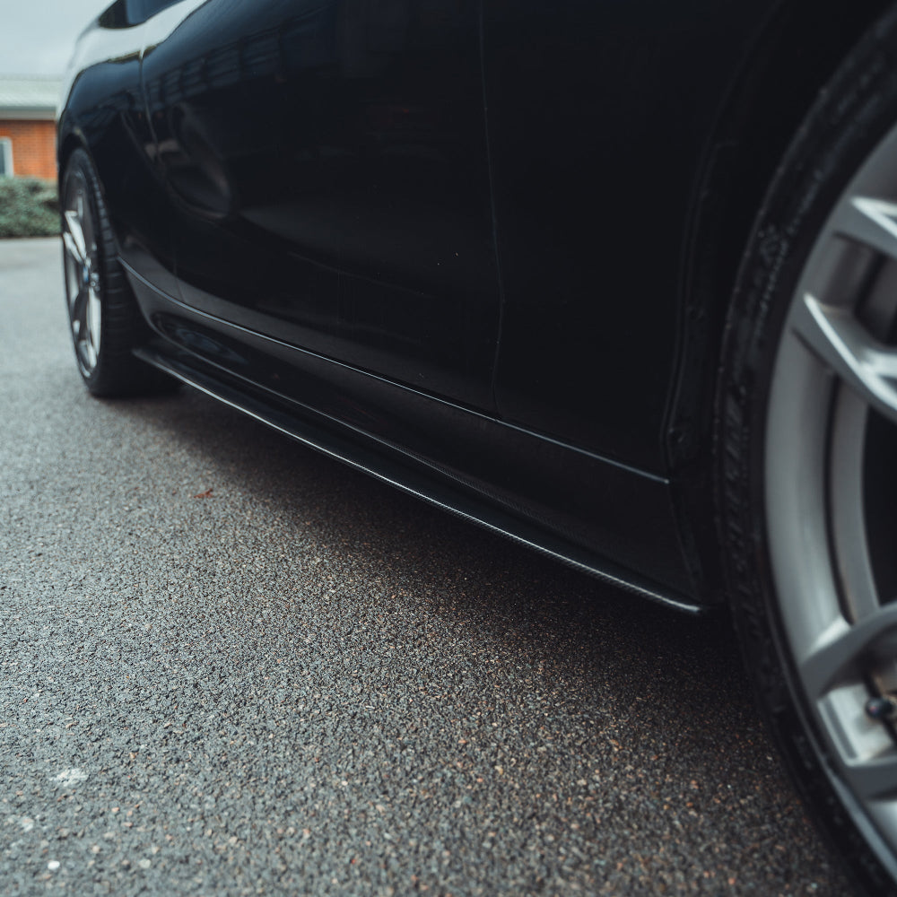 BMW 1 & 2 Series F20/F22/F23 carbon fiber side skirts by CT Carbon, showing sleek, aerodynamic design on a sports car.