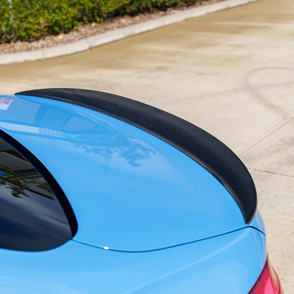 Blue BMW M3 F80 full carbon fiber kit by CT Carbon, including hood, trunk, and side panels, showcasing a sleek carbon finish.