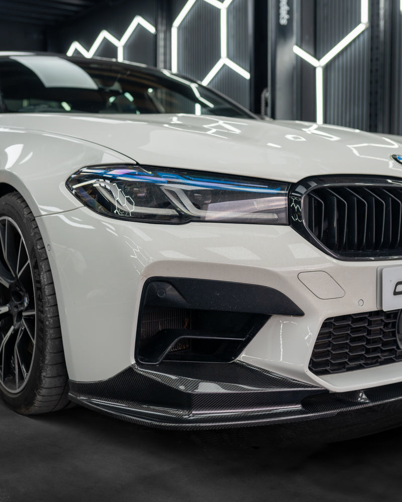BMW F90 M5 carbon fibre splitter by CT Carbon, V4 model, shown installed on the front of the sporty M5 vehicle.