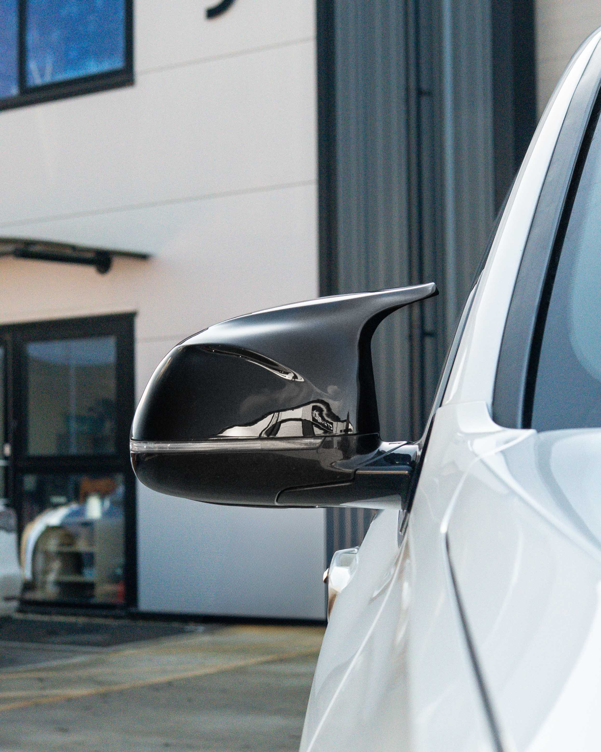 Gloss black BMW F15/F16 X5/X6 mirror covers by CT Carbon, designed for 2014-2018 models, shown on the vehicle.