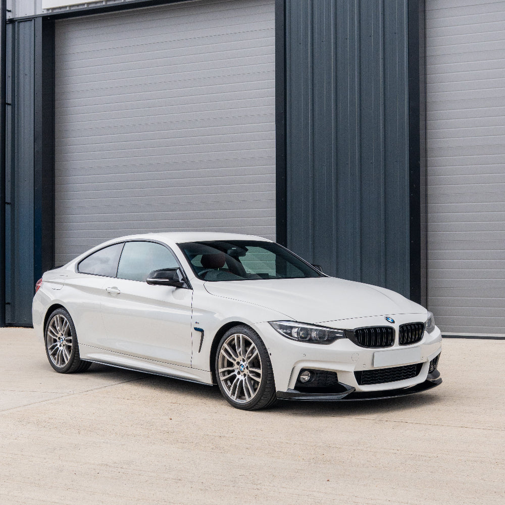BMW 4 Series F32/F33/F36 side skirts by CT Carbon in gloss black, showing the sleek, aerodynamic design on the vehicle side.