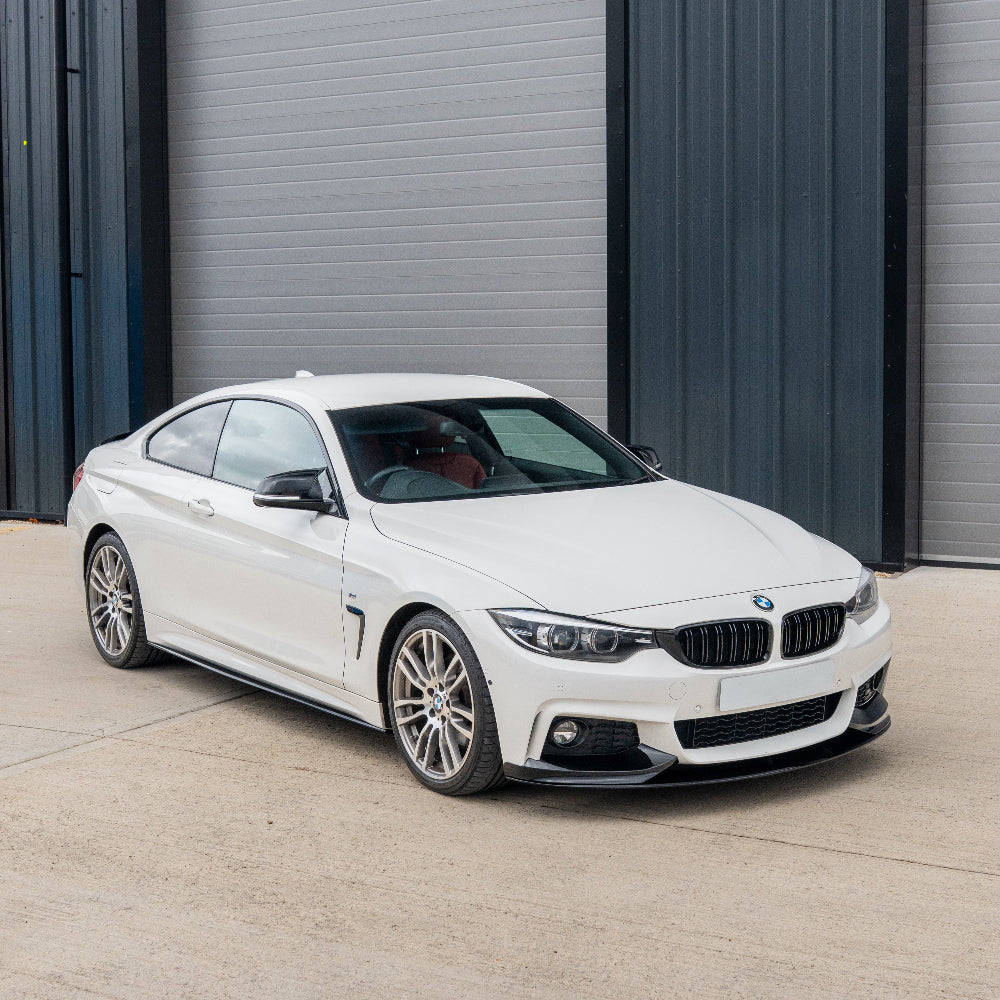 BMW 4 Series F32/F33/F36 CT Carbon gloss black side skirts installed on a car, showcasing sleek aerodynamic design.