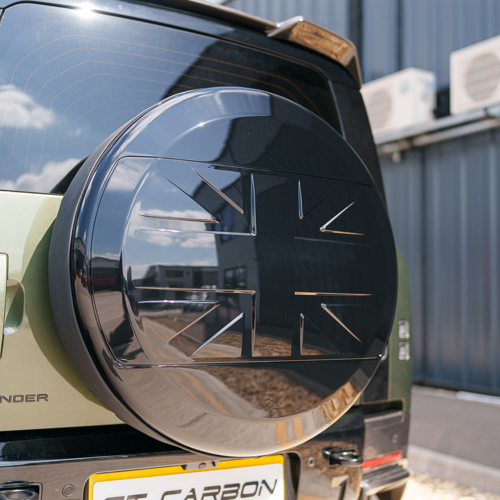 Gloss black spare wheel cover for Land Rover Defender L663 110 & 90 by CT Carbon, designed as a stylish vehicle accessory.
