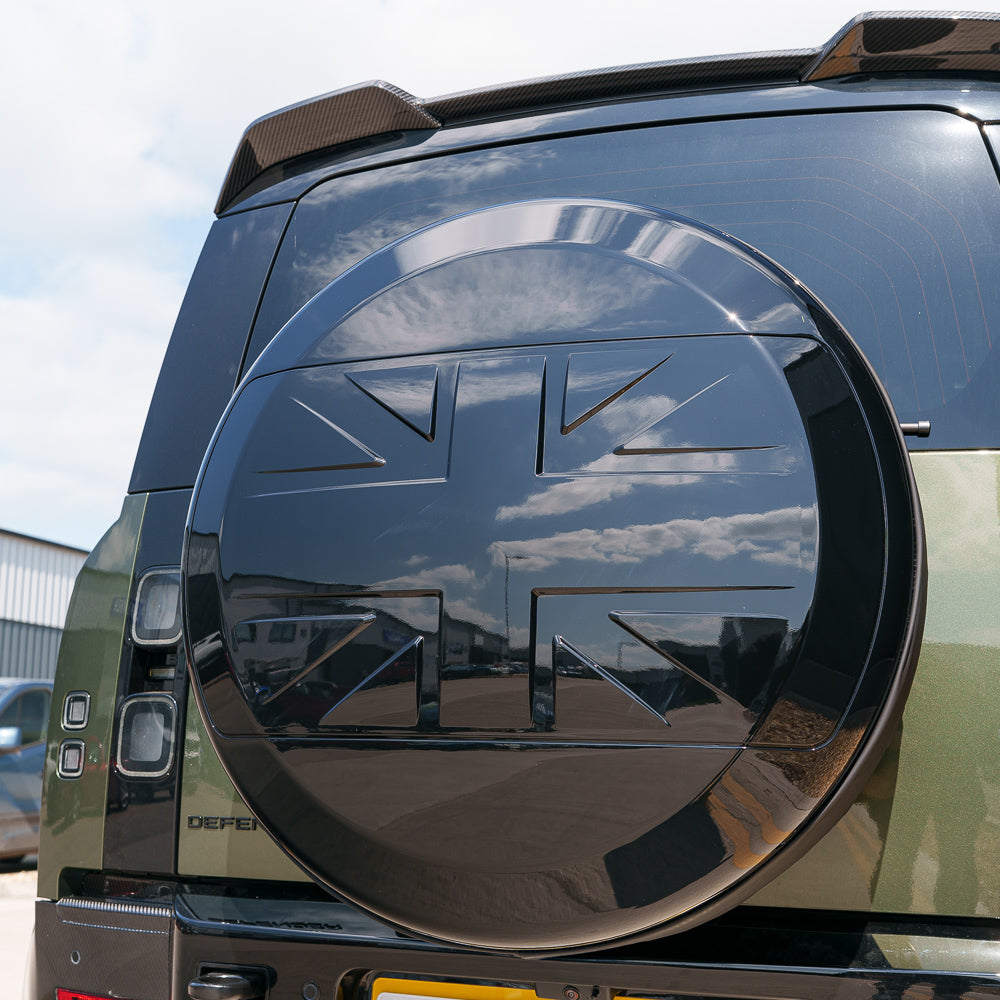 Gloss black spare wheel cover for Land Rover Defender L663 110 and 90 by CT Carbon, designed for a sleek, protective look.