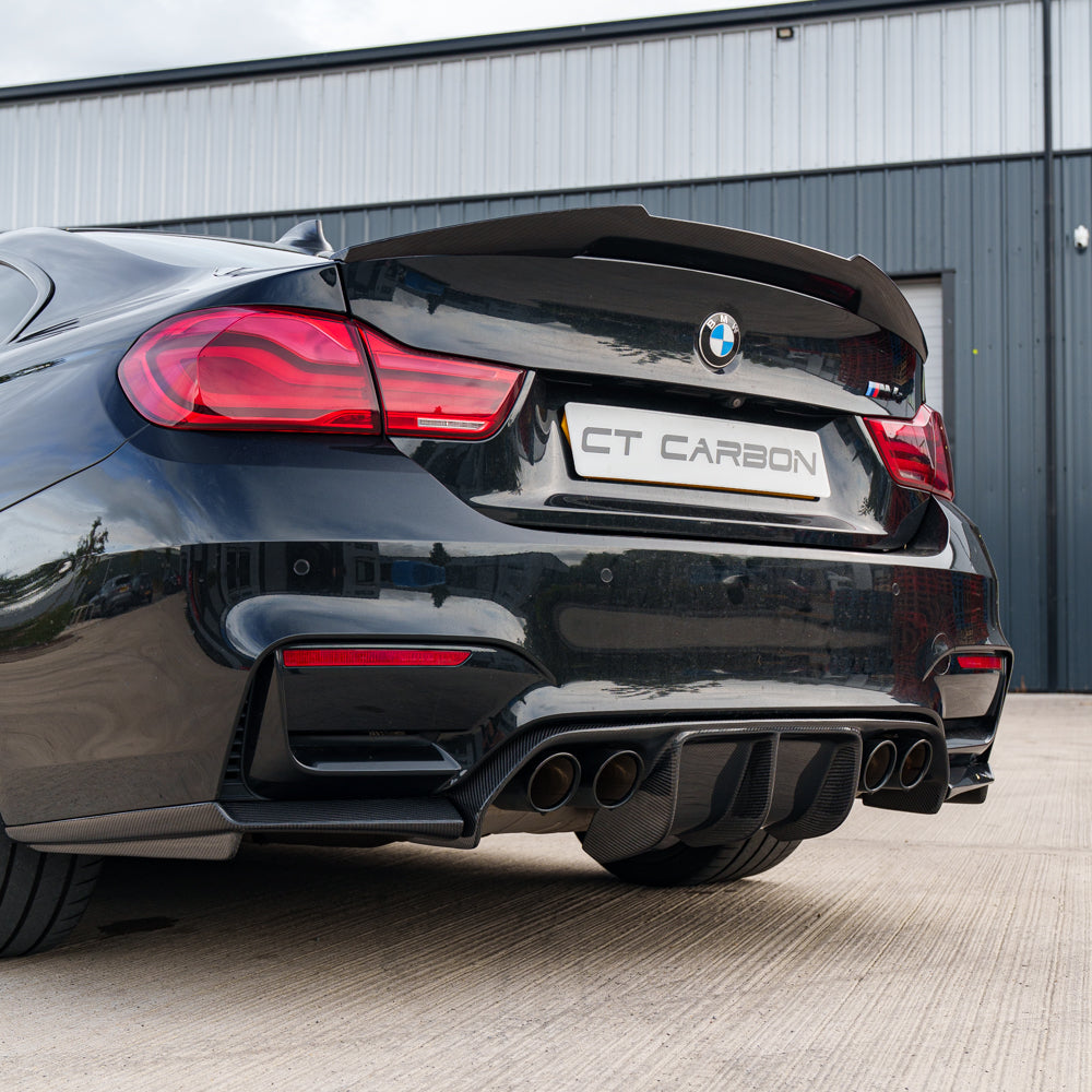 BMW M4 F82 carbon fibre spoiler by CT Carbon, V style, mounted on the car's rear for aerodynamic enhancement.