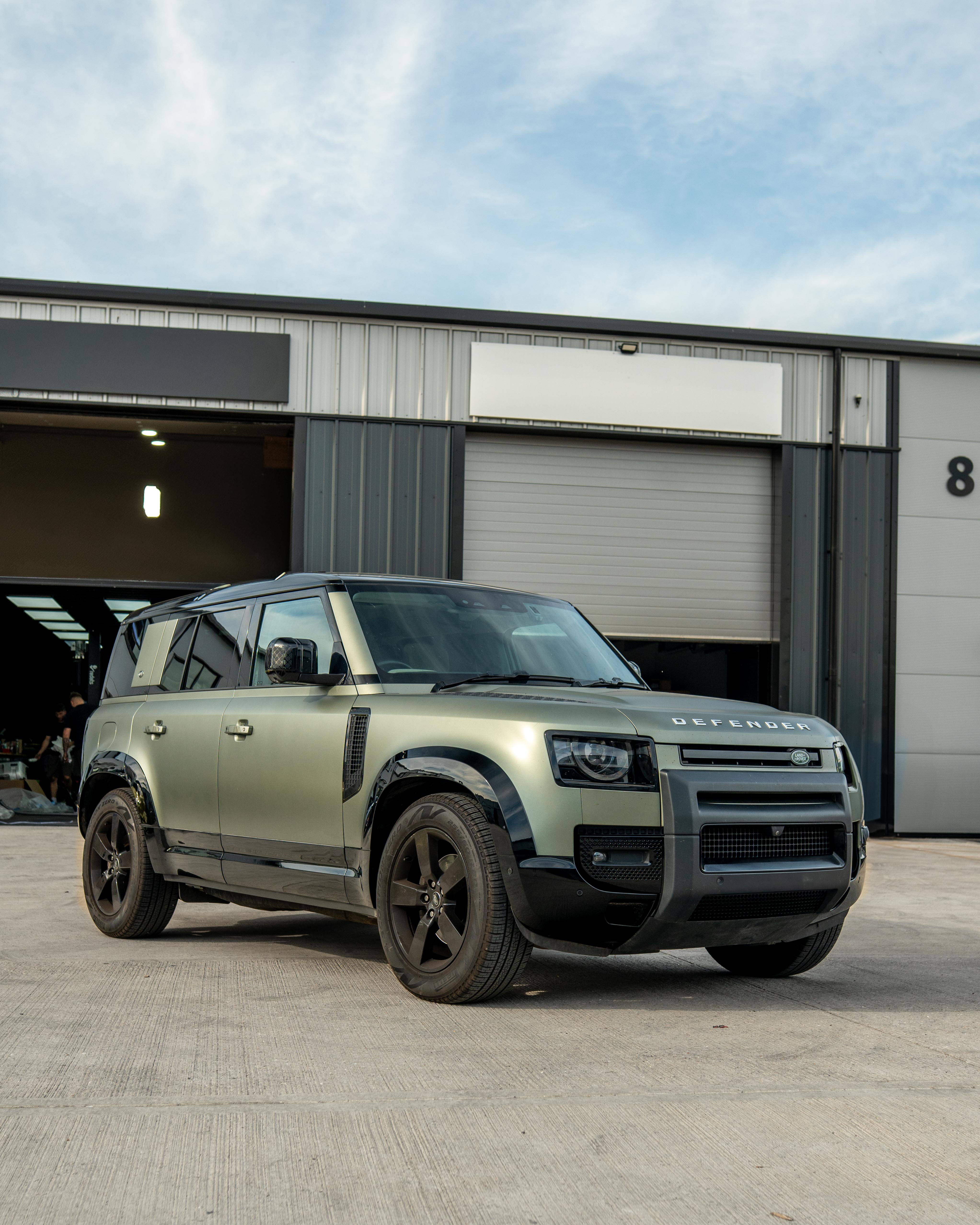 Gloss black door panels for Land Rover Defender L663 110 by CT Carbon, shown in a close-up view of the vehicle's doors.