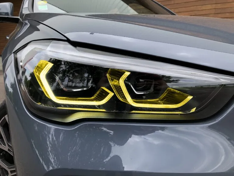 Yellow BMW X1 F48 LCI 2019-2022 adaptive DRL module set by CT Carbon, showcasing the LED daytime running lights on the vehicle.