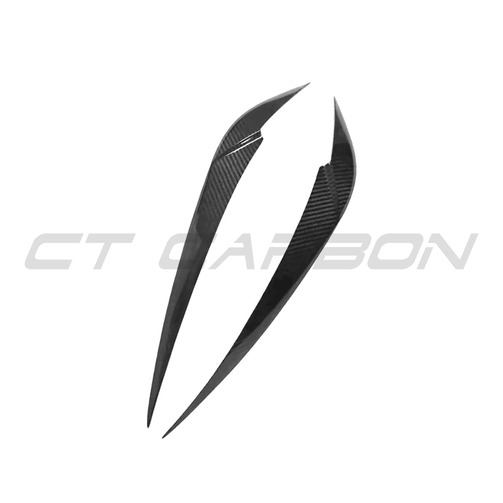 BMW M3 and M4 G8X carbon fiber headlight eyebrow accessory by CT Carbon, showcasing sleek black carbon fiber design on the headlights.