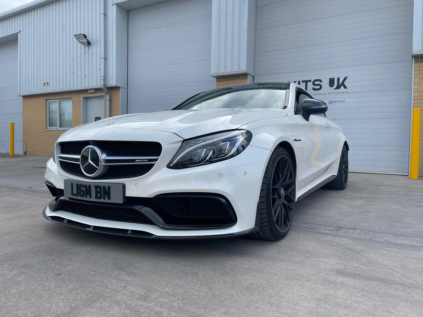 Mercedes C63 W205 coupe convertible CT Carbon V1 carbon splitter, front view showing aerodynamic design and black carbon fiber finish.