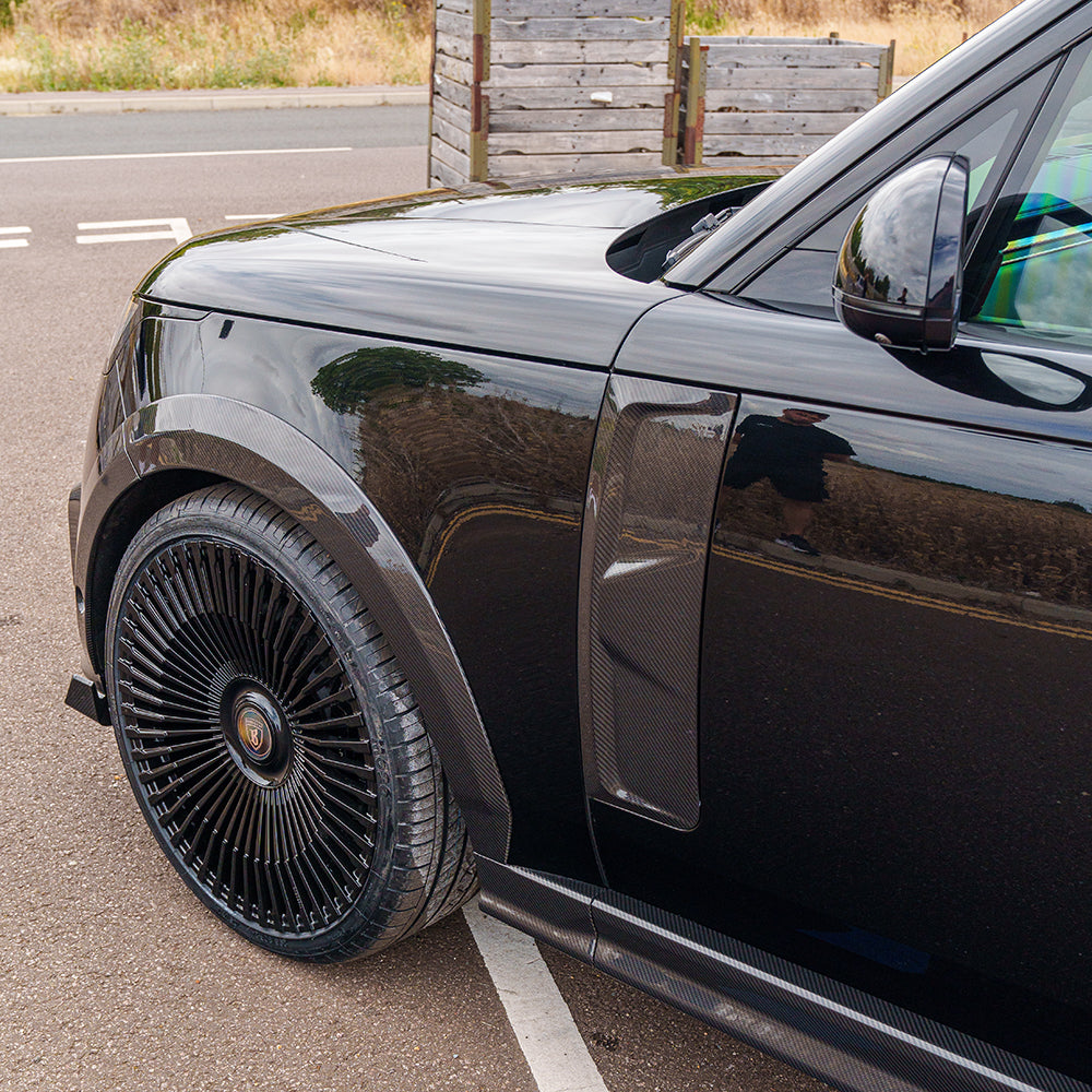 Range Rover L460 2022+ carbon fibre side door trim accessory by CT Carbon, featuring sleek, textured carbon fiber finish on vehicle door.