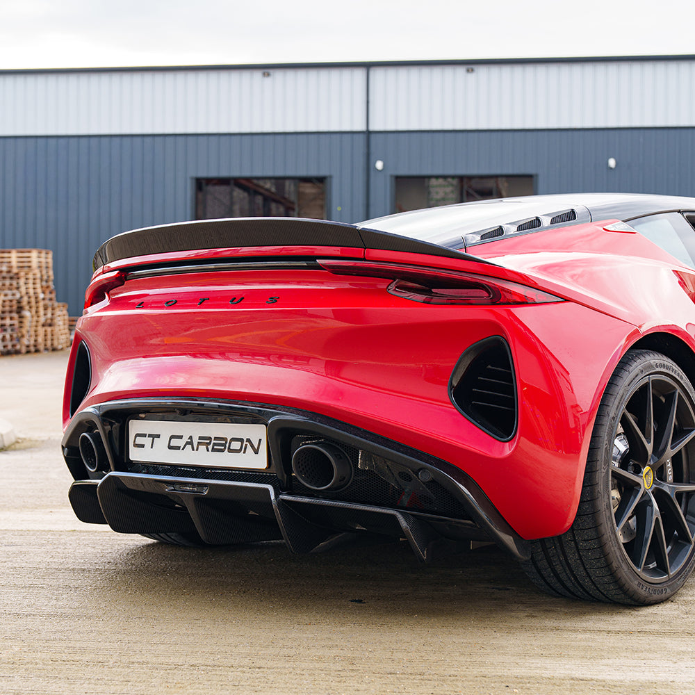 Red Lotus Emira CT Design carbon fiber rear diffuser installed on a sports car, showcasing sleek aerodynamic design.
