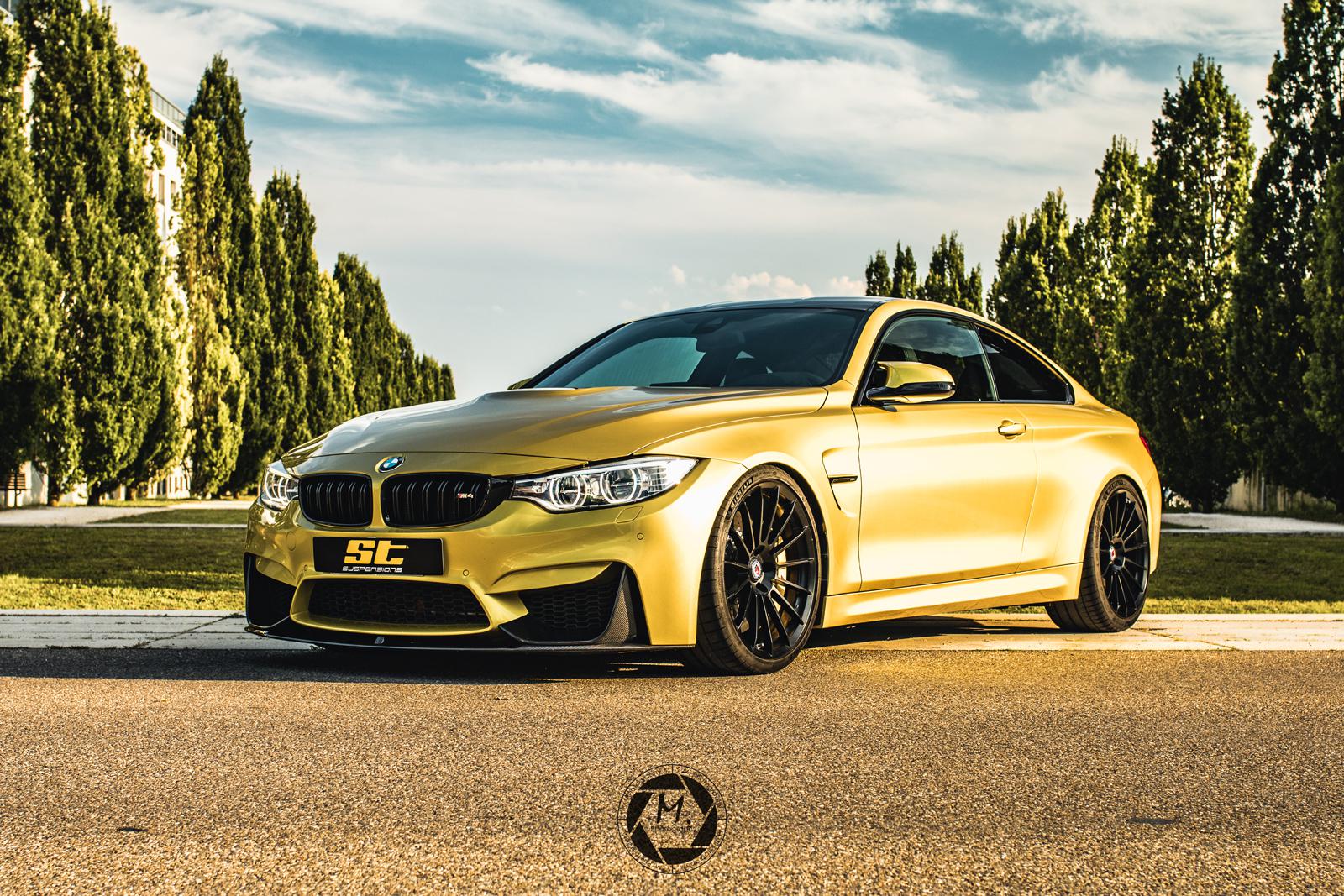 Gold ST Suspension coilovers for BMW F80 M3, F82 M4, F83 M4 with adjustable damping and top mounts, shown on a BMW F82 M4 coupe.