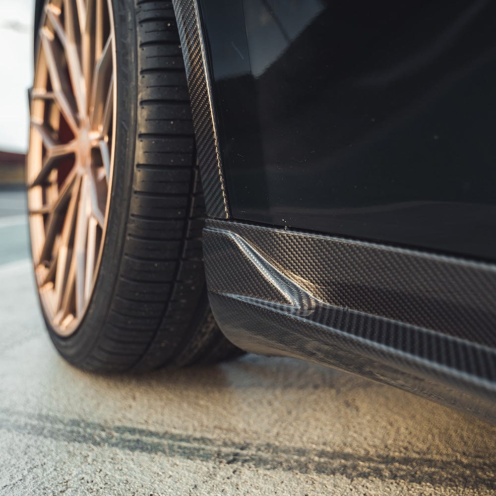 Tesla Model Y MK1 2020-2025 carbon fibre side skirts by CT Carbon, shown installed on the vehicle's sides.
