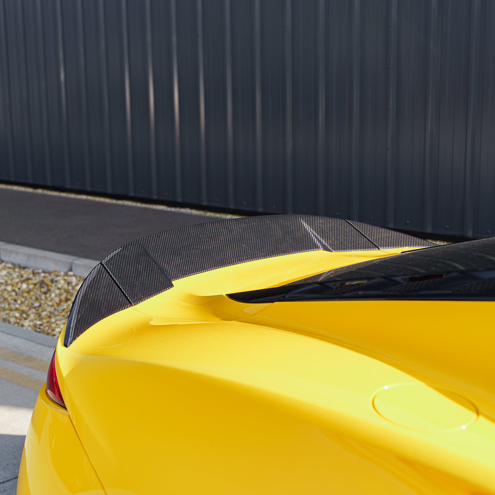 Yellow Lotus Emira with CT Carbon fiber 3-piece spoiler, showcasing sleek aerodynamic design on a car.