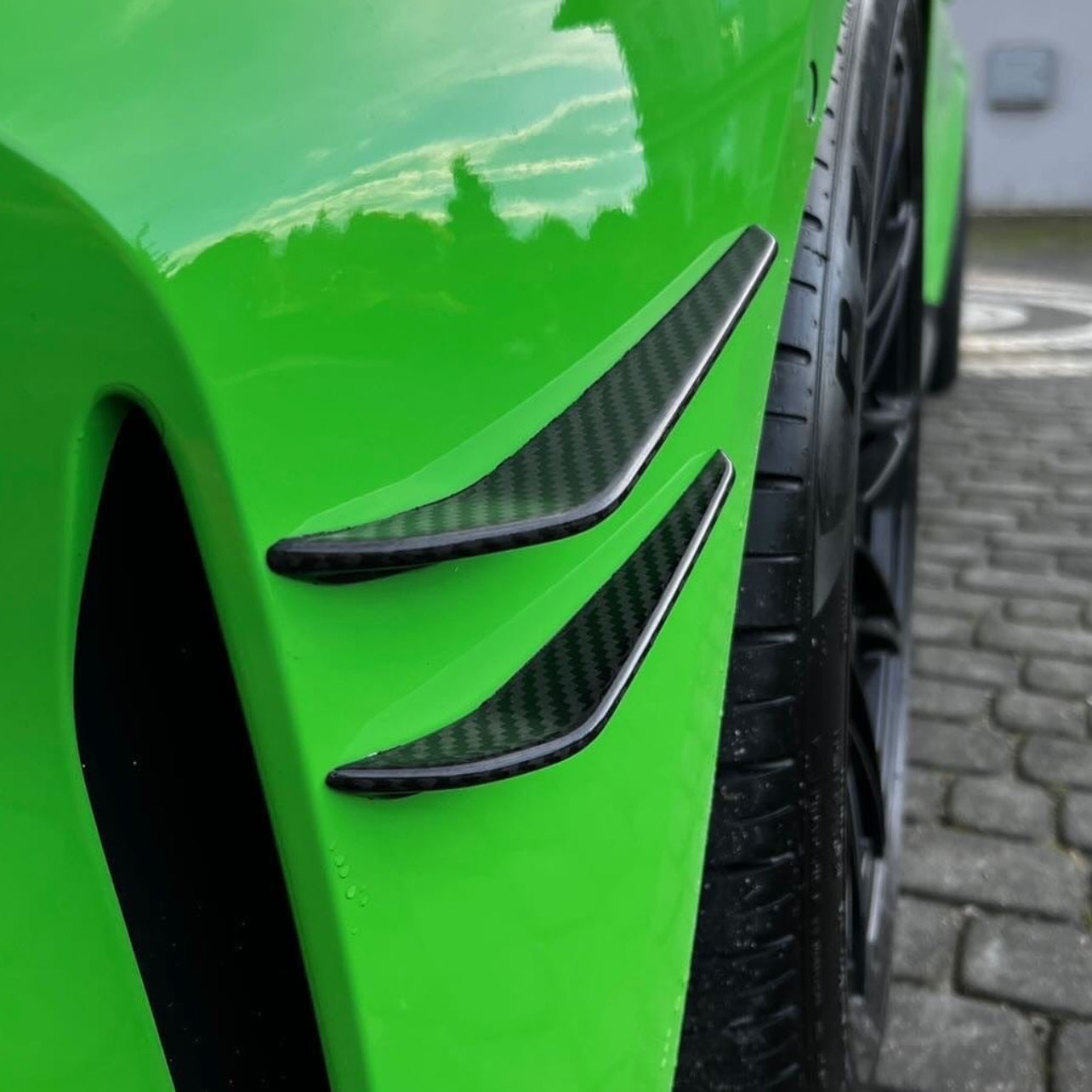 BMW M3 M4 G80 G82 G81 G83 carbon fiber front bumper canards by CT Carbon, showing sleek aerodynamic design details.