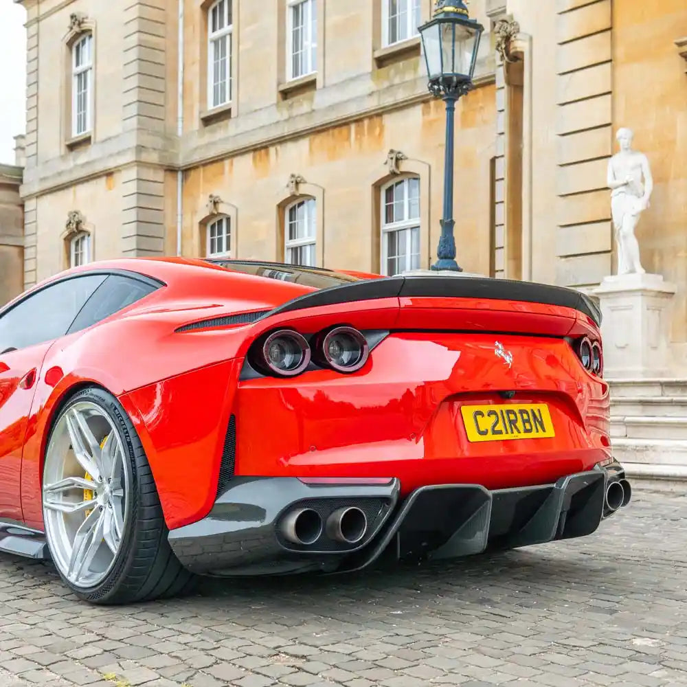 Ferrari 812 Superfast carbon fibre diffuser by CT Carbon, showcasing sleek aerodynamic design and textured carbon fibre surface.