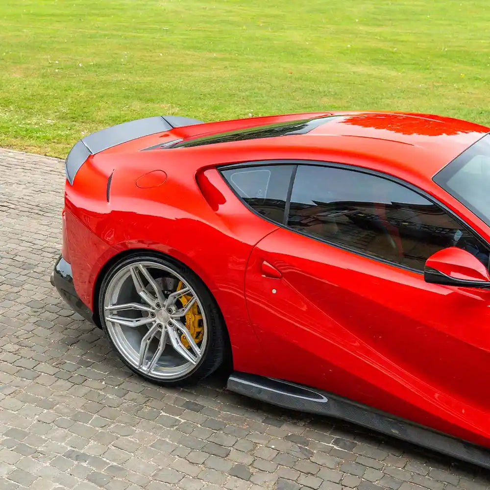Ferrari 812 Superfast and GTS carbon fiber side skirt extensions by CT Carbon, shown installed on the car's side.