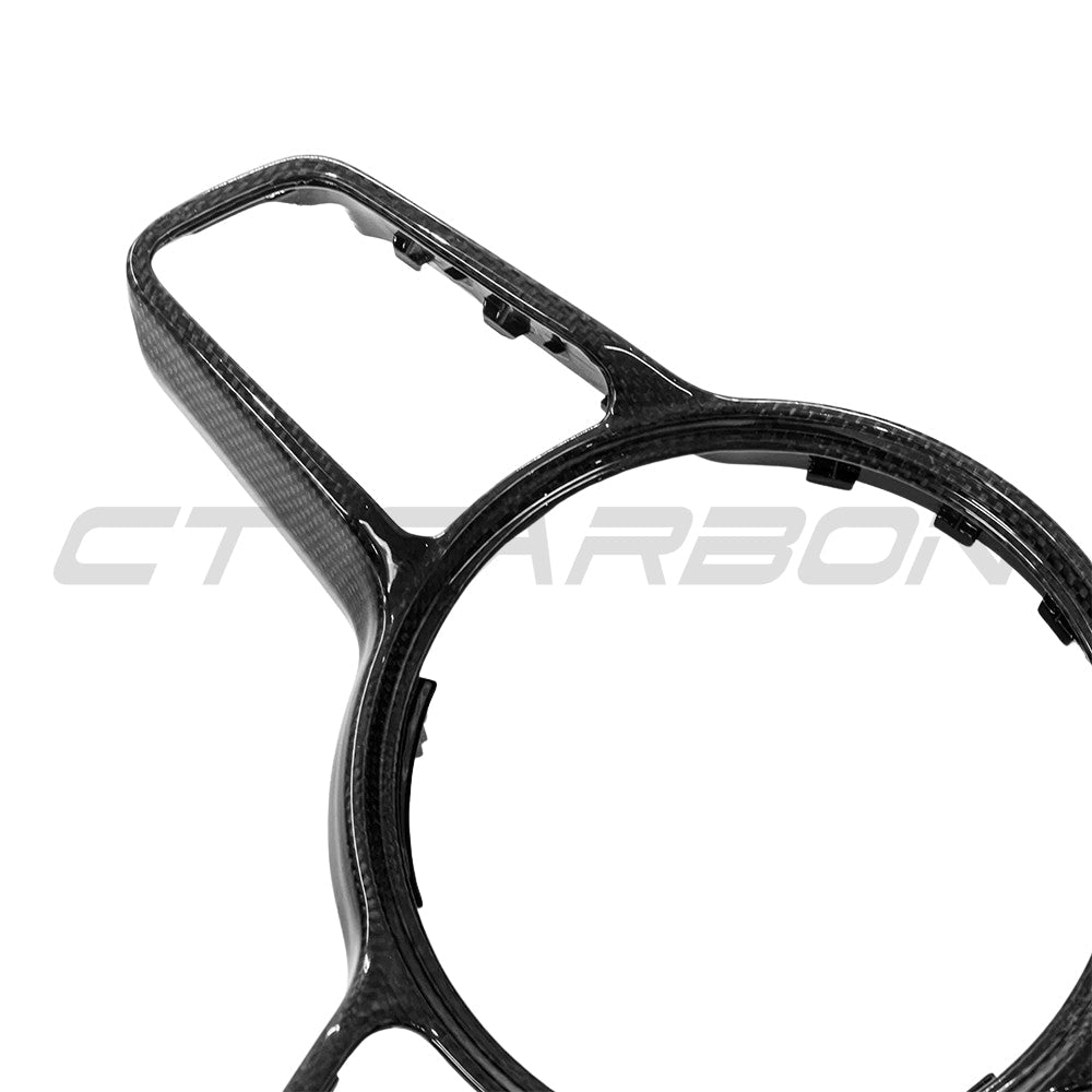 CT Carbon steering wheel trim for Porsche 911, Cayman, Boxster, Cayenne, Macan models 2013+, showing close-up of glossy carbon fiber finish.