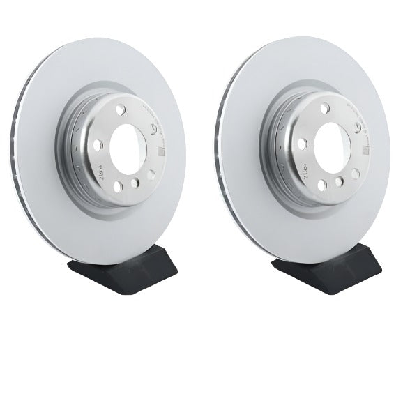 Two brake rotors on black stands against a white background