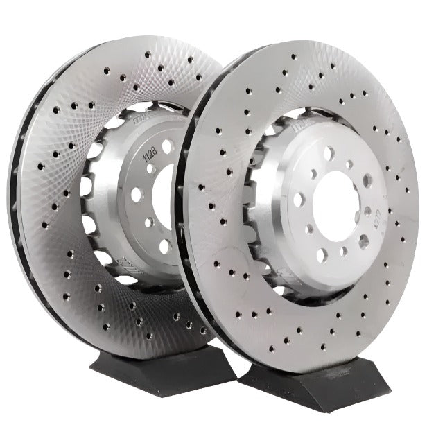Two metallic brake rotors on a stand against a white background