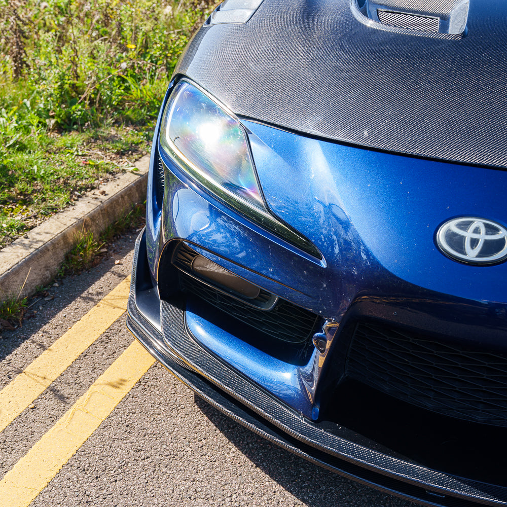 Carbon fiber splitter for Toyota Supra 2019+ A90 V2 by CT Carbon, shown installed on the front of the sports car.