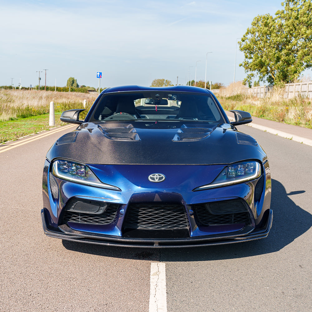 Carbon fiber splitter for Toyota Supra 2019+ A90 by CT Carbon, showcasing the sleek, aerodynamic V2 design on the car's front bumper.