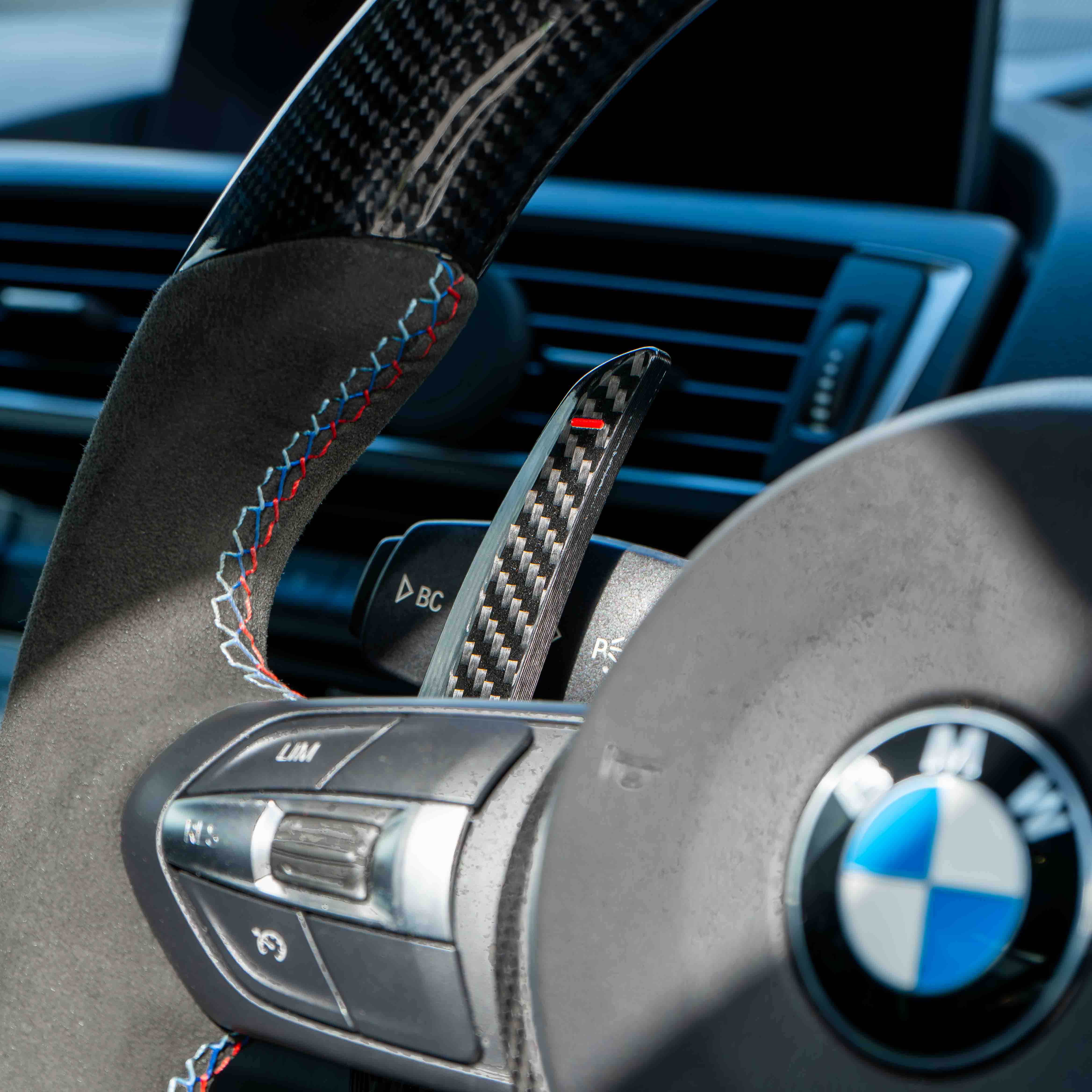 BMW carbon fiber magnetic shifter paddles by CT Carbon, showcasing sleek black design and textured carbon fiber surface.
