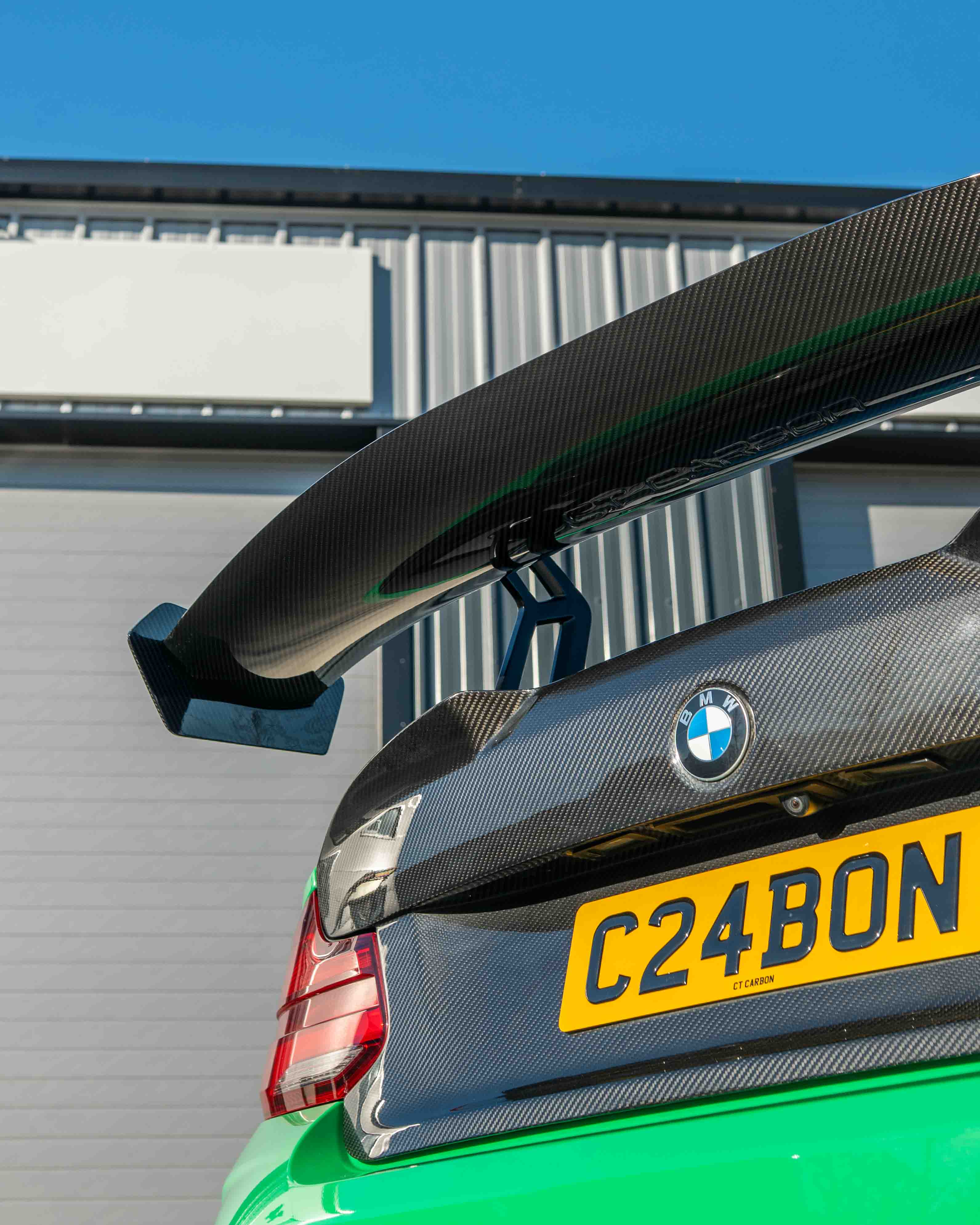 BMW F87 M2 and F22 2 Series carbon fibre swan neck wing spoiler by CT Carbon, showcasing sleek V8 design and aerodynamic details.