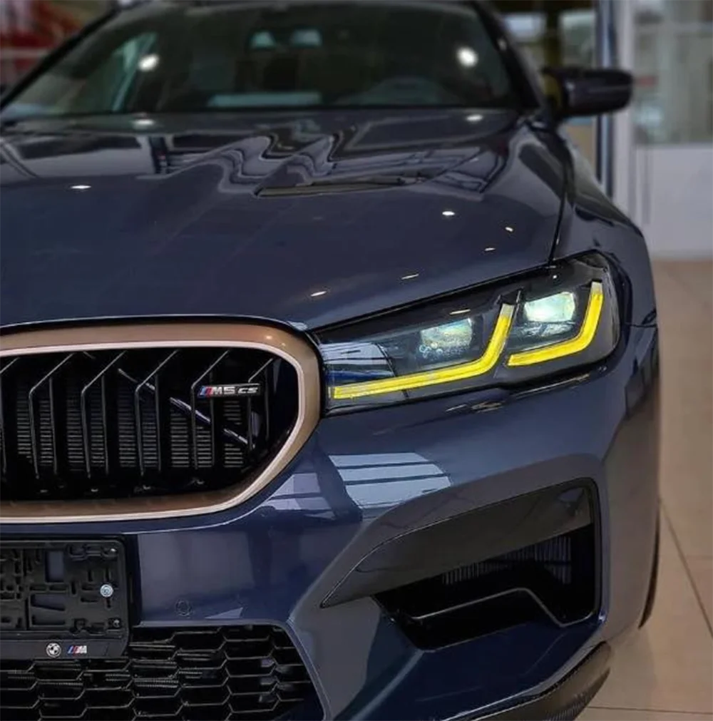 BMW F90 M5 LCI yellow adaptive DRL module set by CT Carbon, showing close-up of the yellow LED daytime running lights on the car.