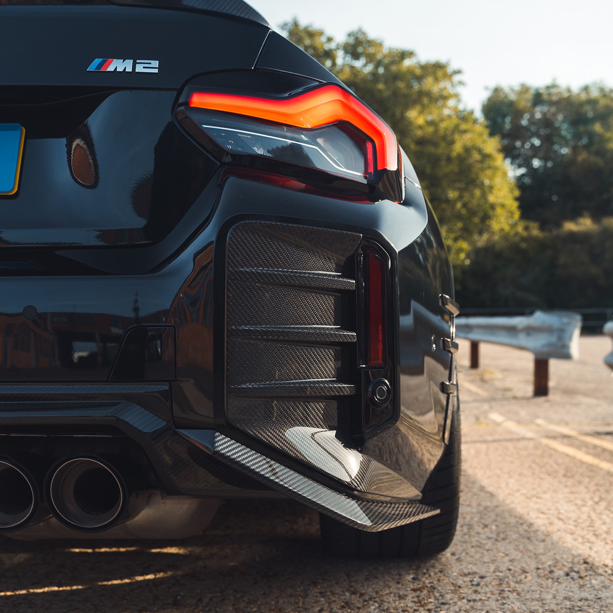 BMW G87 M2 carbon fiber rear bumper trim accessory by CT Carbon, showing close-up of sleek, lightweight carbon fiber finish.